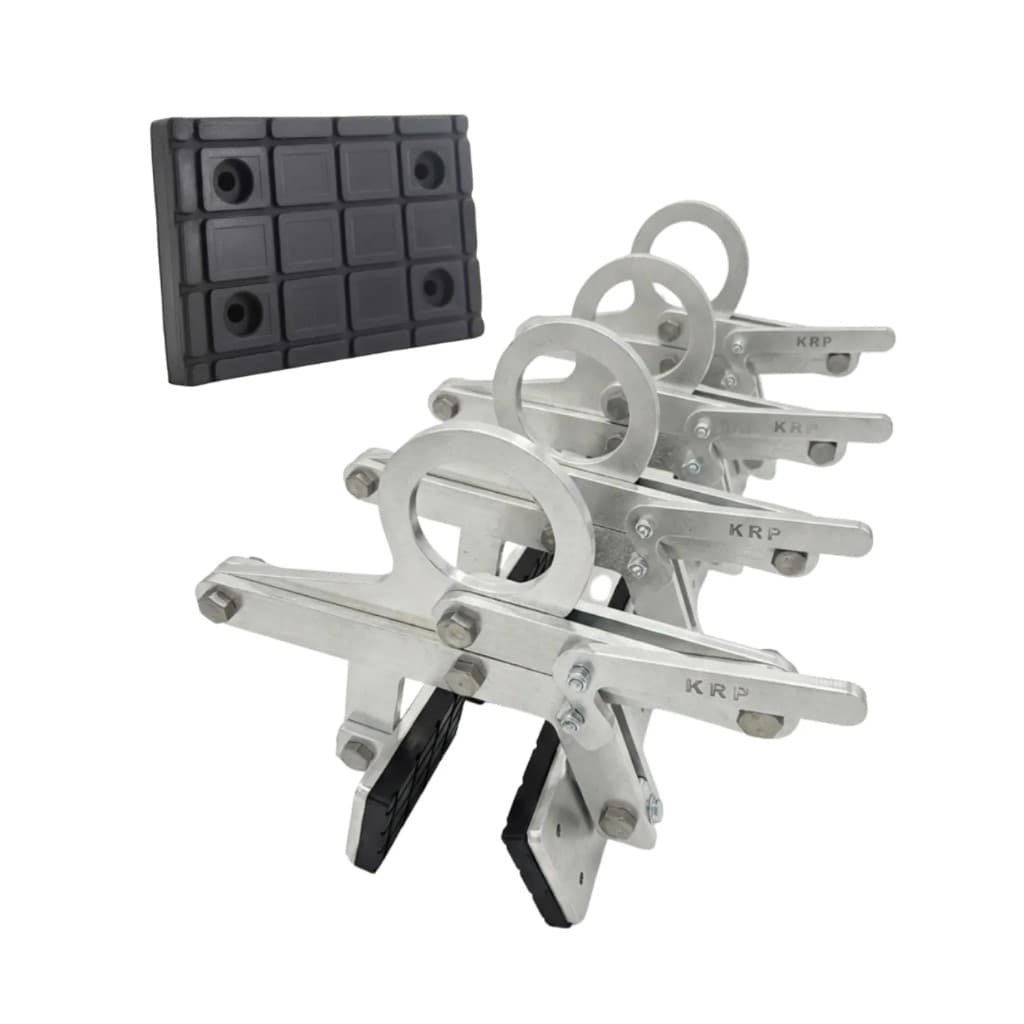 Four silver KRP lifting clamps in perspective with one black rubber pad on white background